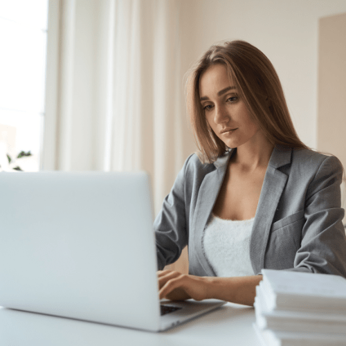 Kvinne jobber på laptop i kontor